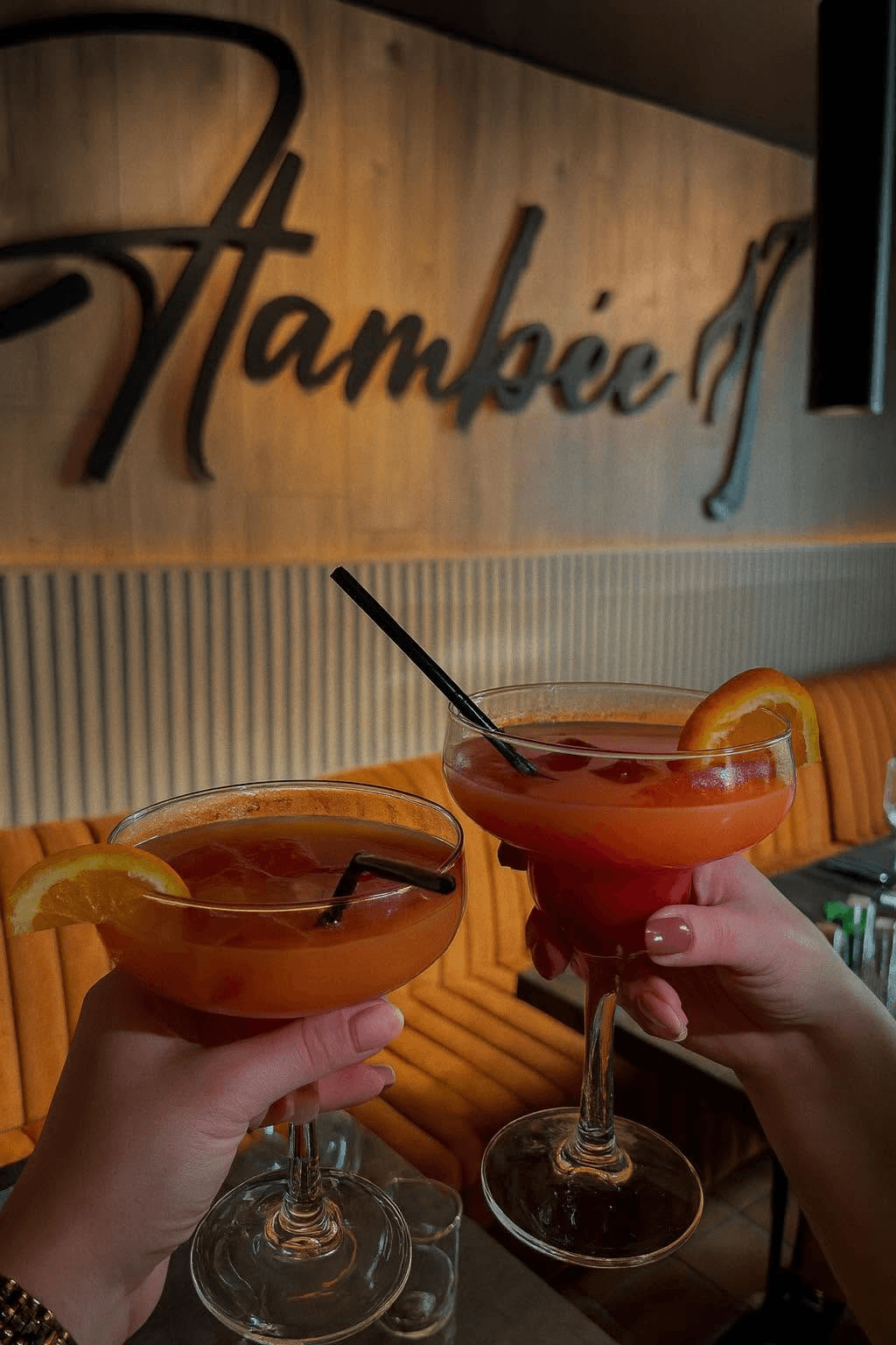 Deux verres levés dans la salle de La Flambée, ambiance conviviale